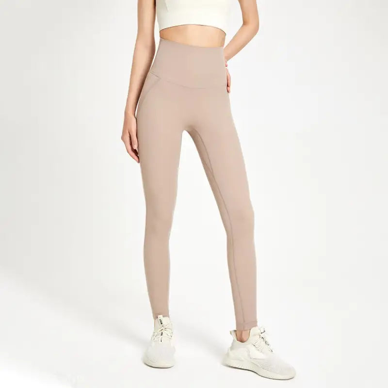 Beige high-waist leggings with white sneakers in wild berry color