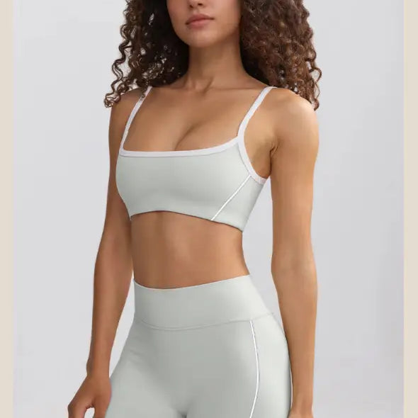 Woman wearing a white sports bra and matching high-waisted shorts.