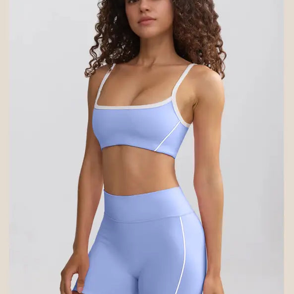 Woman wearing a light blue sports bra and matching high-waisted shorts.