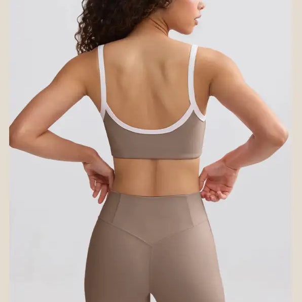 Woman wearing a taupe sports bra and matching high-waisted shorts, viewed from behind.
