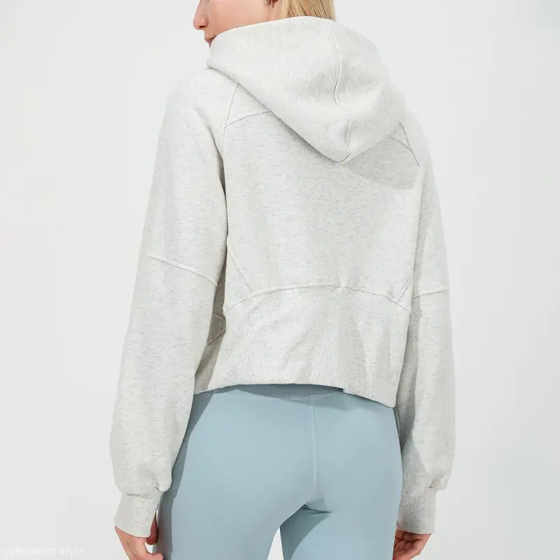 Cropped white hooded sweatshirt over light blue leggings for morning running warm workout