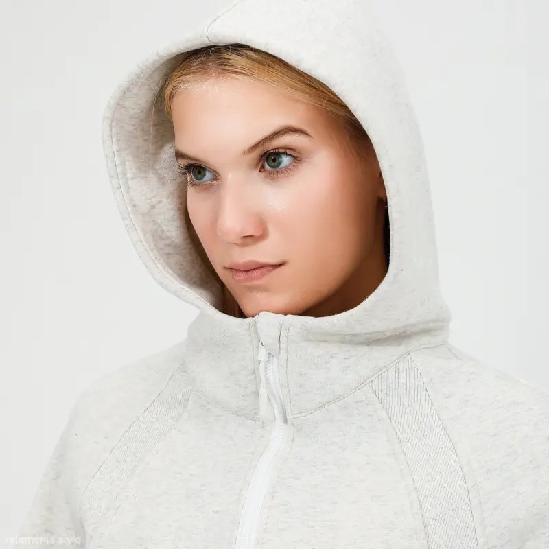 Woman wearing a white hooded sweatshirt ideal for morning running warm workouts
