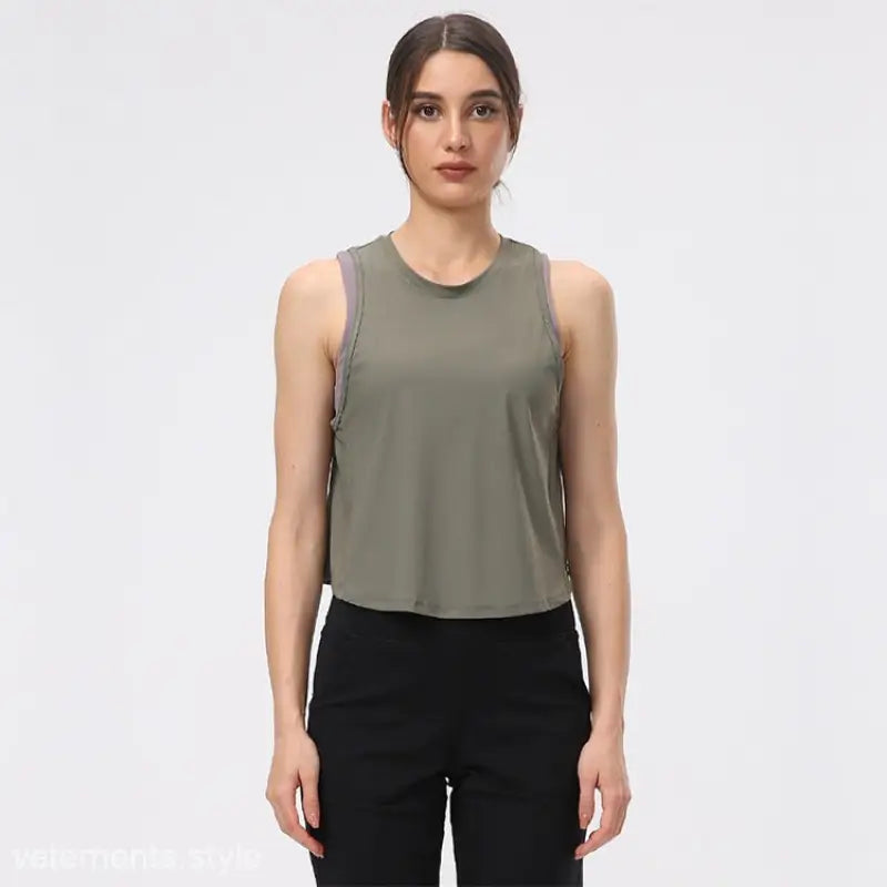 Woman wearing a sleeveless Chinese Olive Green and Midnight Blue Half Waist Blouse and black pants