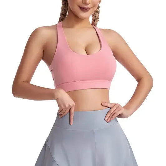 Woman in pink sports bra and gray skirt wearing a boost shape workout bra with steel ring