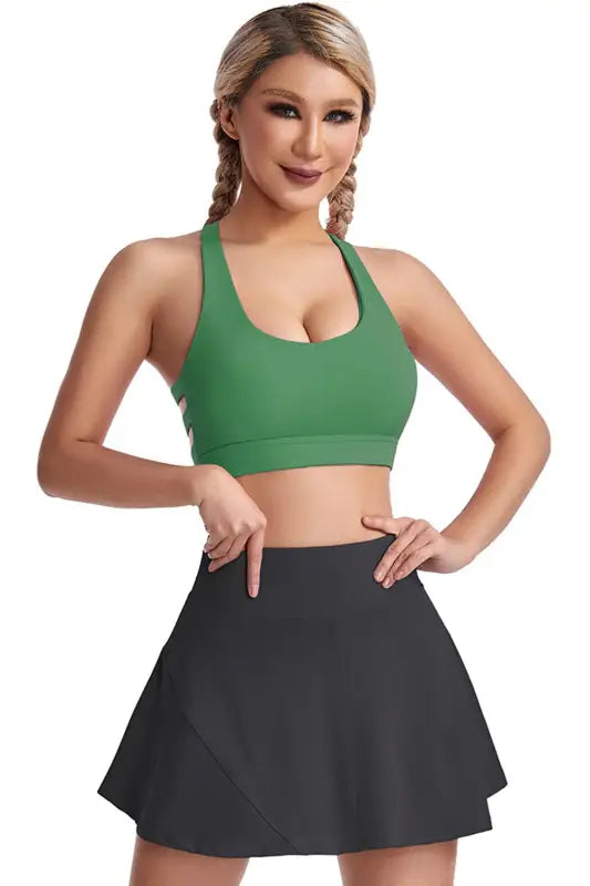 Woman wearing a green boost shape bra and black skirt, showcasing the Workout Bra design