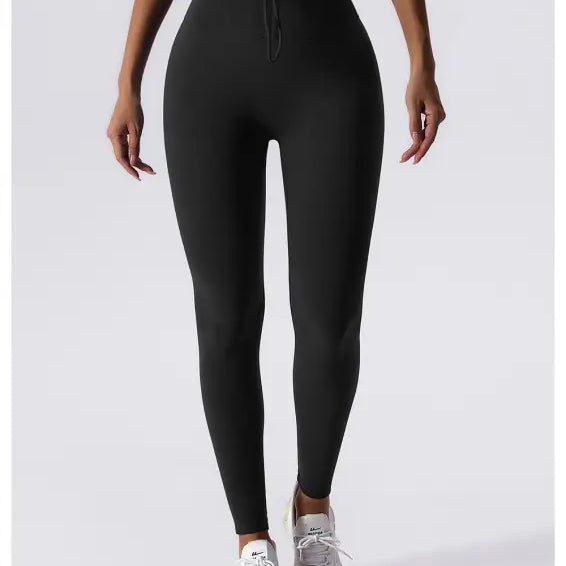 Black high-waisted leggings with white sneakers, perfect for Sporty Nylon Solid Pants