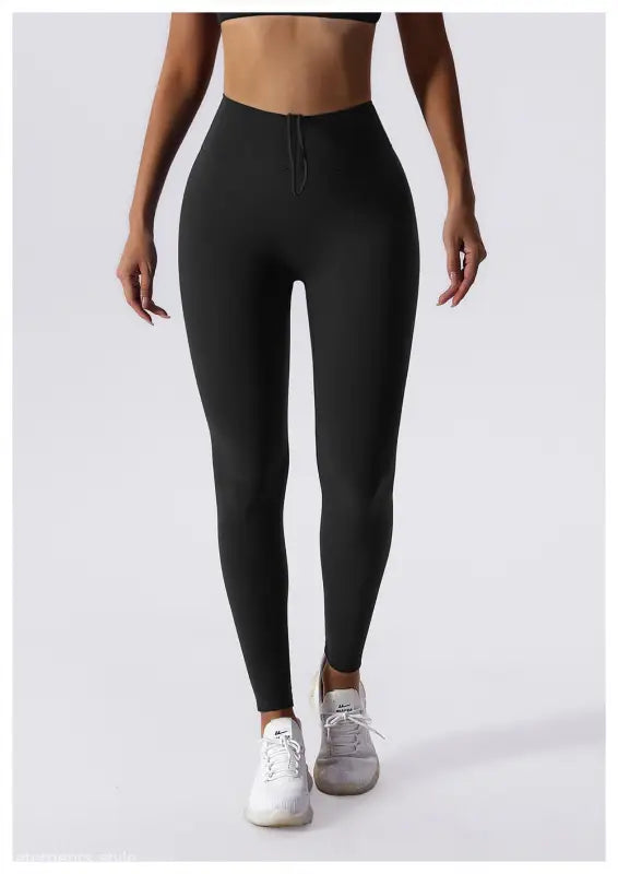 Black high-waisted leggings with white sneakers, perfect for Sporty Nylon Solid Pants