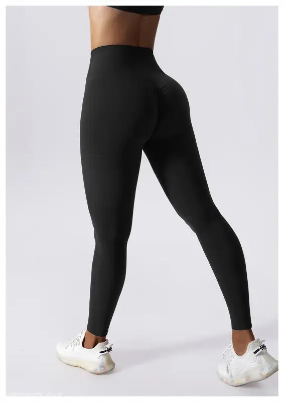 Black high-waisted athletic leggings styled with white sneakers, perfect for workouts