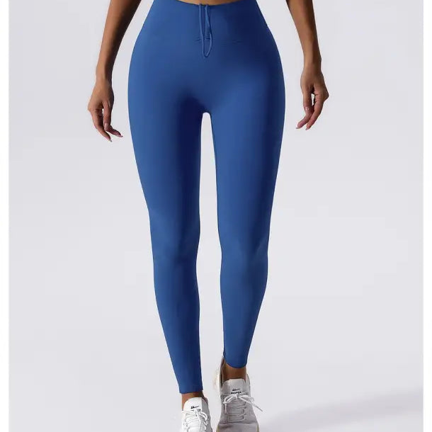 Blue high-waisted athletic leggings paired with white sneakers for Sporty Nylon Solid Pants