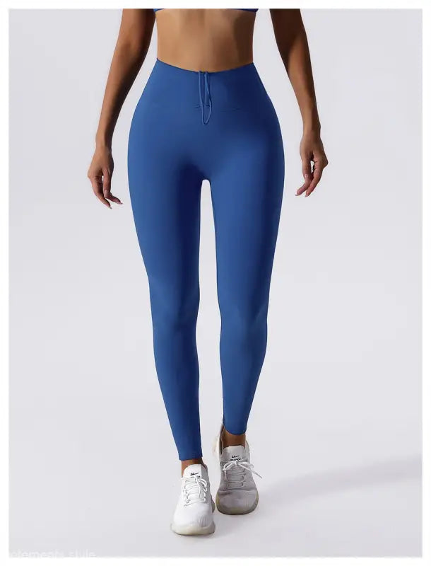 Blue high-waisted athletic leggings paired with white sneakers for Sporty Nylon Solid Pants