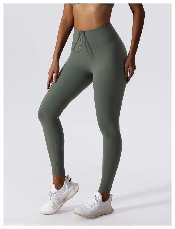 Olive green high-waisted athletic leggings with a drawstring waistband in Sporty Nylon Solid Pants