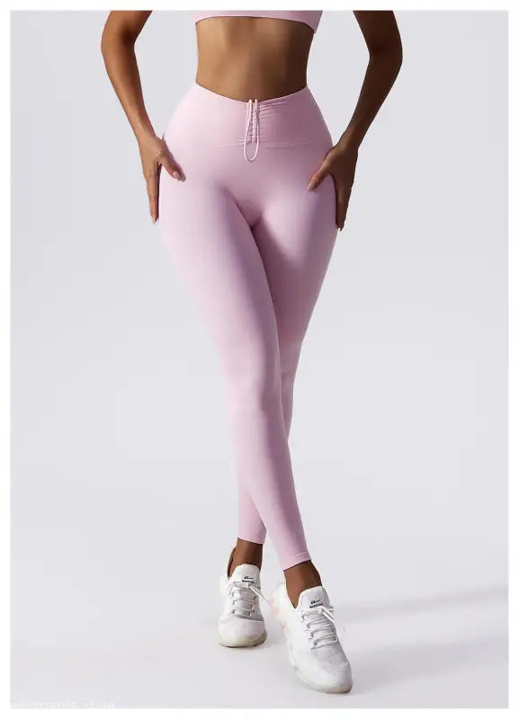 Pale pink high-waisted leggings styled with white sneakers from Sporty Nylon Solid Pants