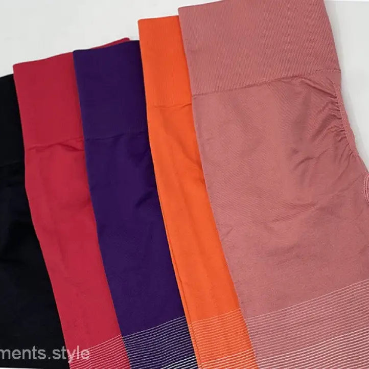 Colorful array of women’s athletic leggings including purple long sleeve and ombre orange pink pants