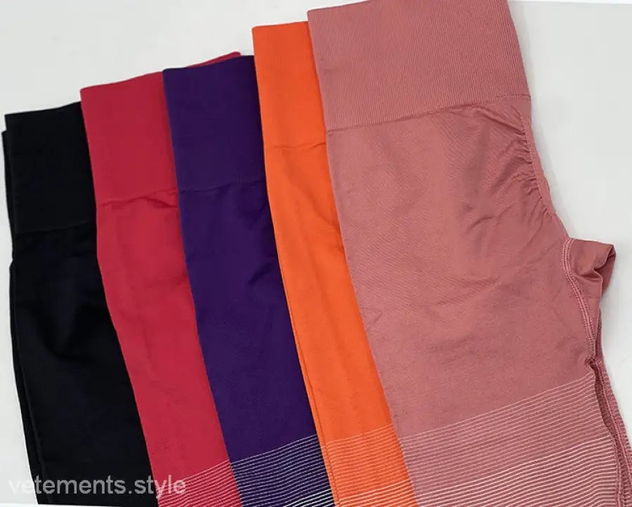 Colorful array of women’s athletic leggings including purple long sleeve and ombre orange pink pants