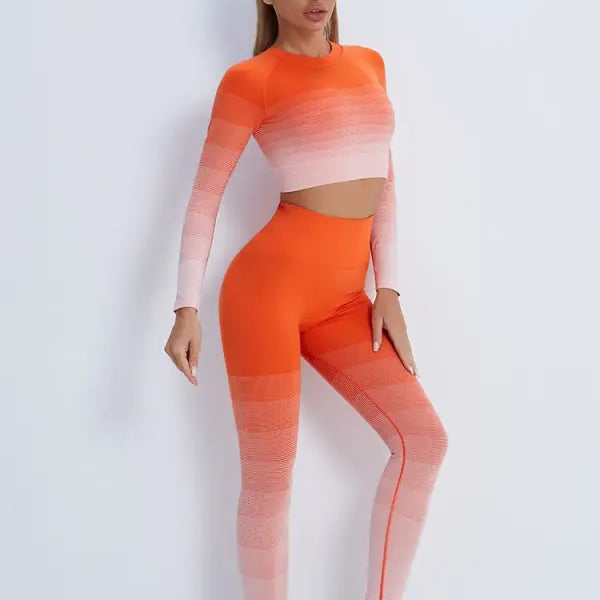 Woman wearing vibrant orange pink ombré workout set with purple long sleeve and high-waisted leggings