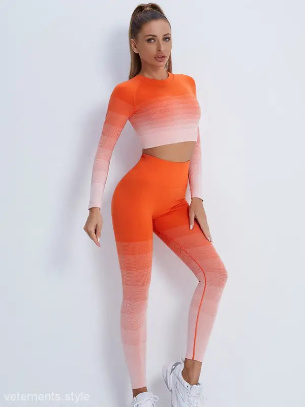 Woman wearing vibrant orange pink ombré workout set with purple long sleeve and high-waisted leggings