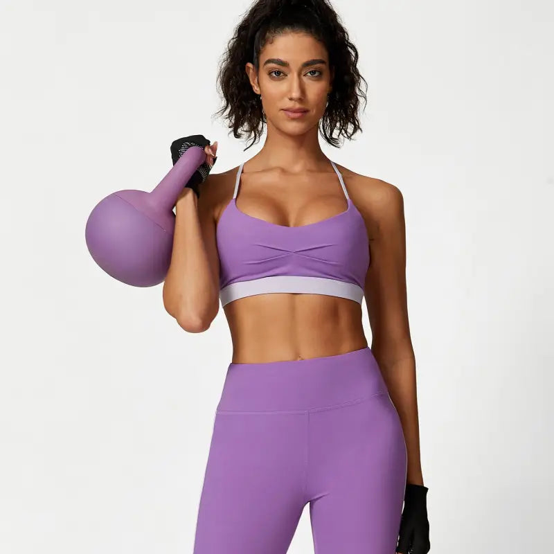 Woman in purple workout attire showcasing the Sporty Slim Nylon Color Block Cutout Set for Waist Hip Lift