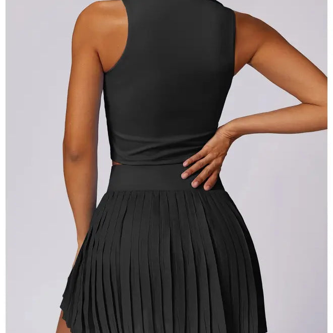 Black sleeveless top paired with pleated mini skirt in Swan White Suit style