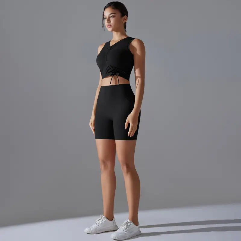 Woman in black athletic wear showcasing the Sporty Slim Nylon Sleeveless High Rise Yoga Set for fitness yoga
