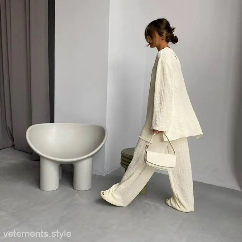 Woman in stitching crepe casual suit walking past modern chair