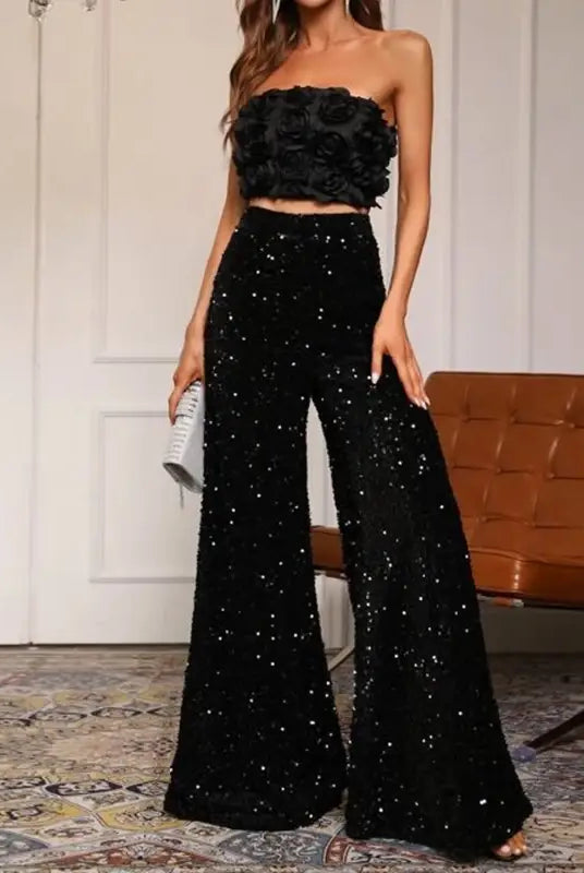 Glamorous black two-piece outfit with floral strapless top and sequined high waist pants