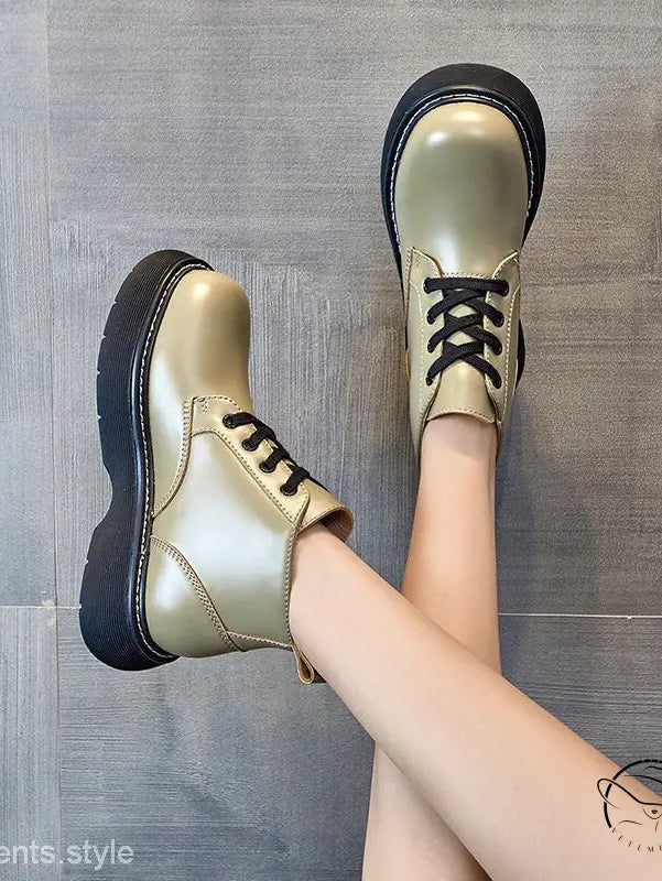 Stylish thick-sole leather ankle boots in metallic gold with black laces