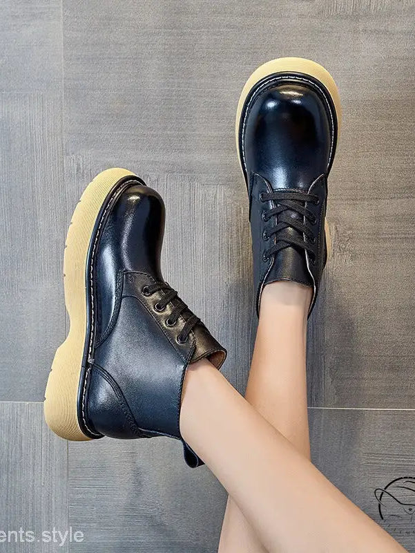 Stylish thick-sole leather boots in black with yellow soles and laces