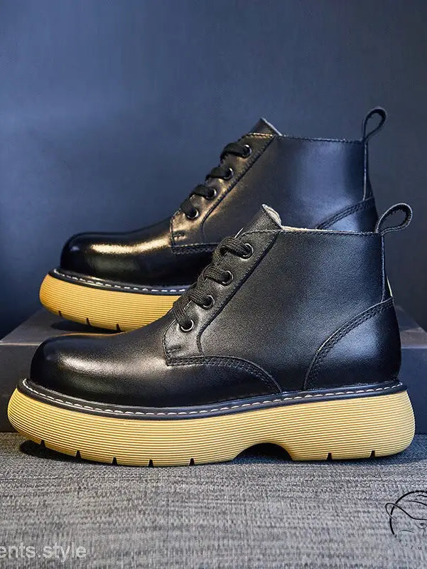 Pair of stylish thick-sole leather boots in black with yellow soles