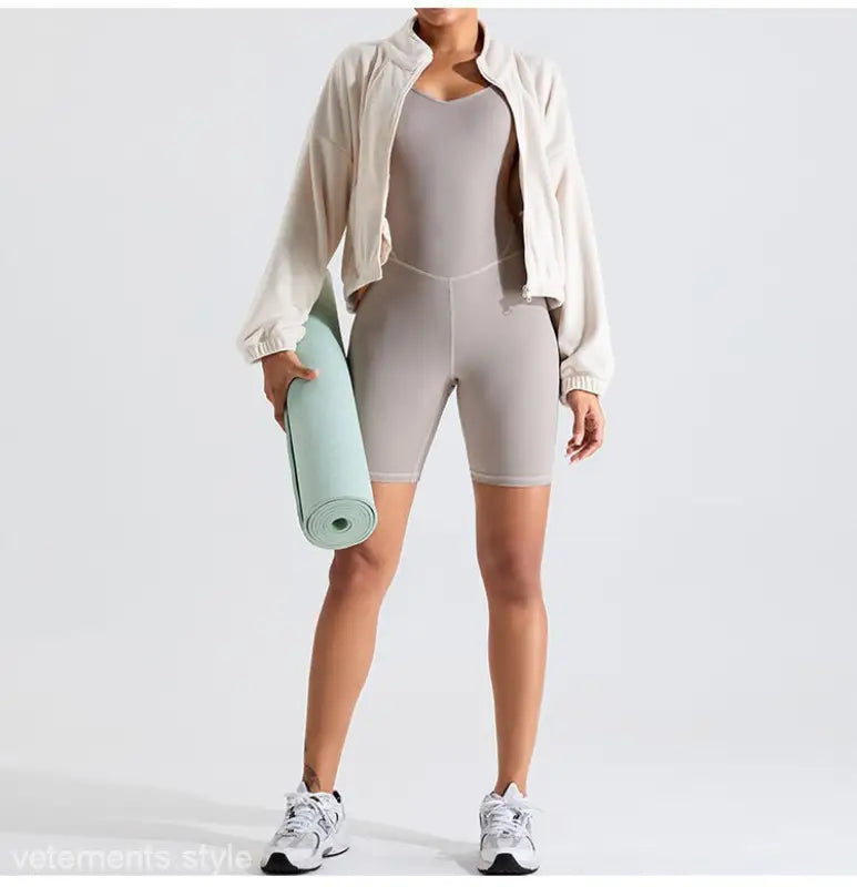 Woman in athletic wear holding yoga mat wearing Temperament Pink fleece sports jacket