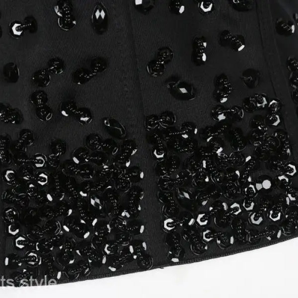 Three dimensional black corset top with rhinestone beadwork on black background