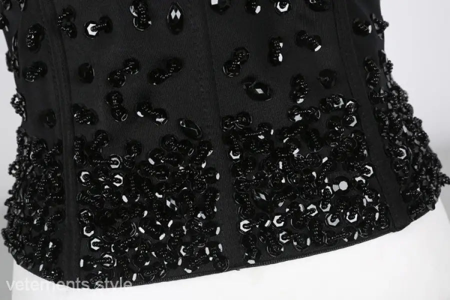 Three dimensional black corset top with rhinestone beadwork on black background