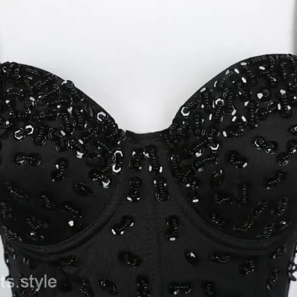 Black sequined three dimensional corset top with rhinestone detail on black background