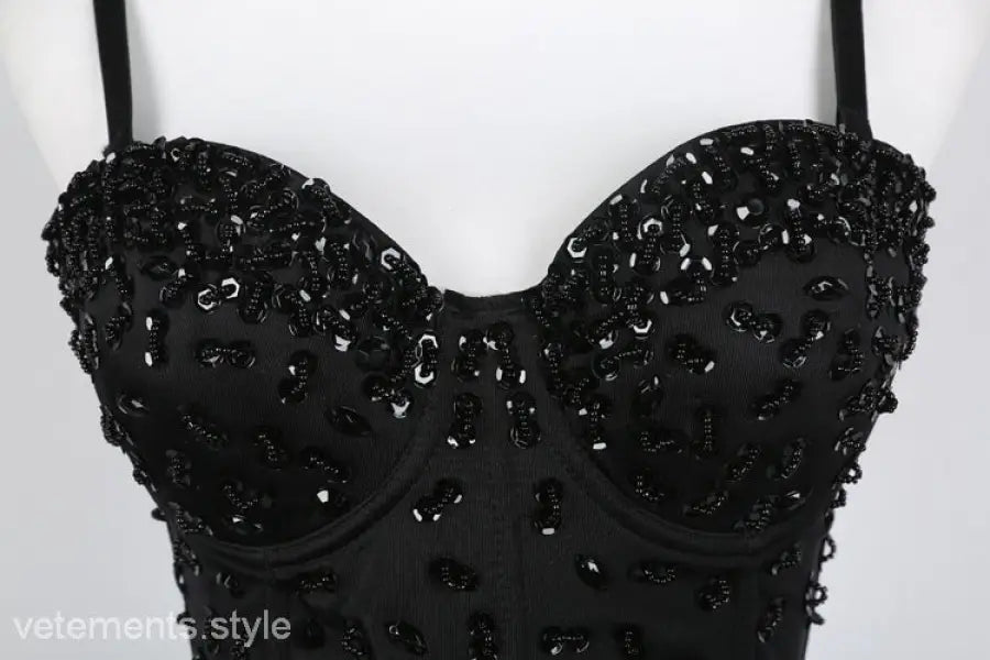 Black sequined three dimensional corset top with rhinestone detail on black background