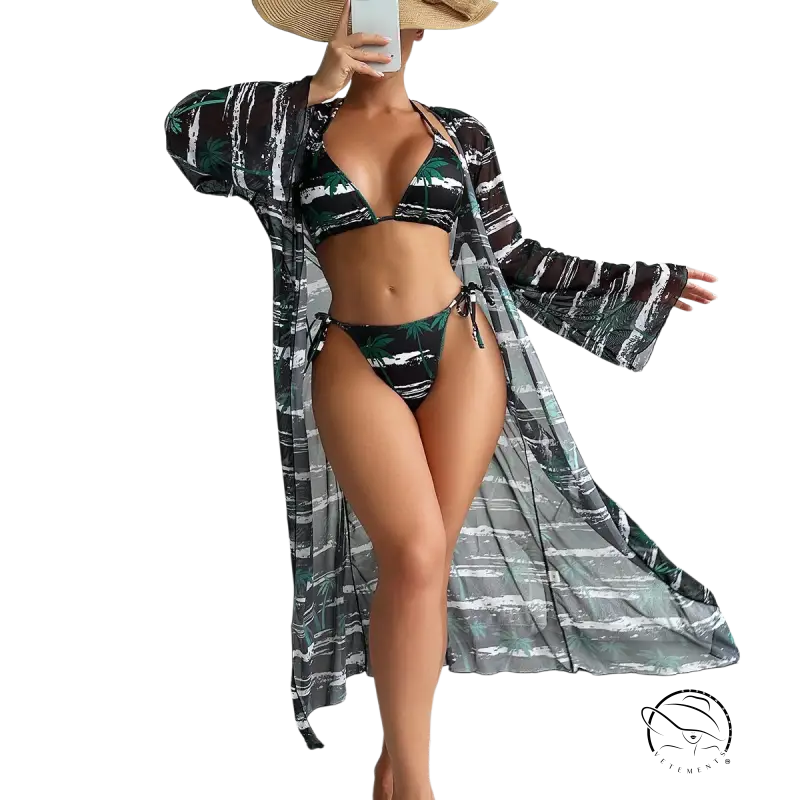 Woman in three piece long sleeve swimsuit with tropical lace, robe, and straw hat