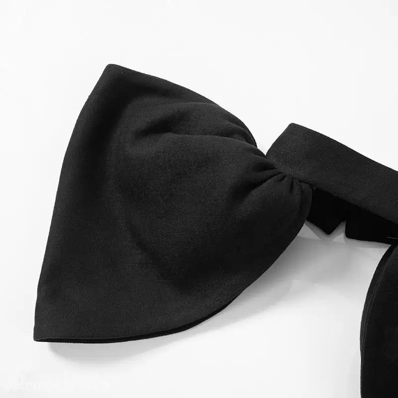 Black fabric bow accessory on trendy open bone dress for an elegant look