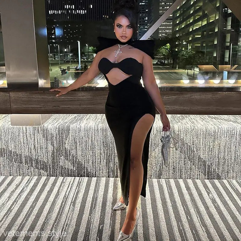 Woman in black trendy open bone dress showcasing asymmetric cutout bodycon midi style