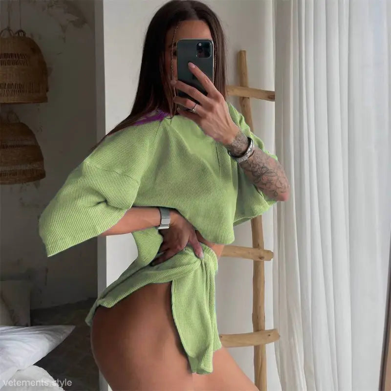 Woman in a green knit set showcasing a unique loose outfit with a stylish short sleeve top