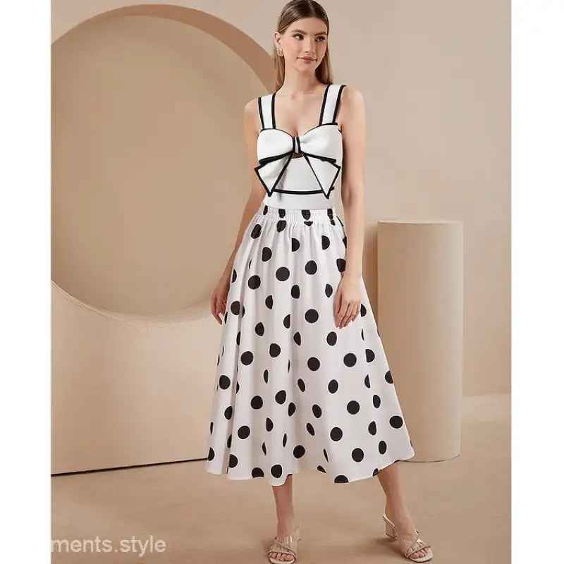 Woman in polka dot dress models White Swimsuit and Chiffon Beach Skirt Set with Bow Detail