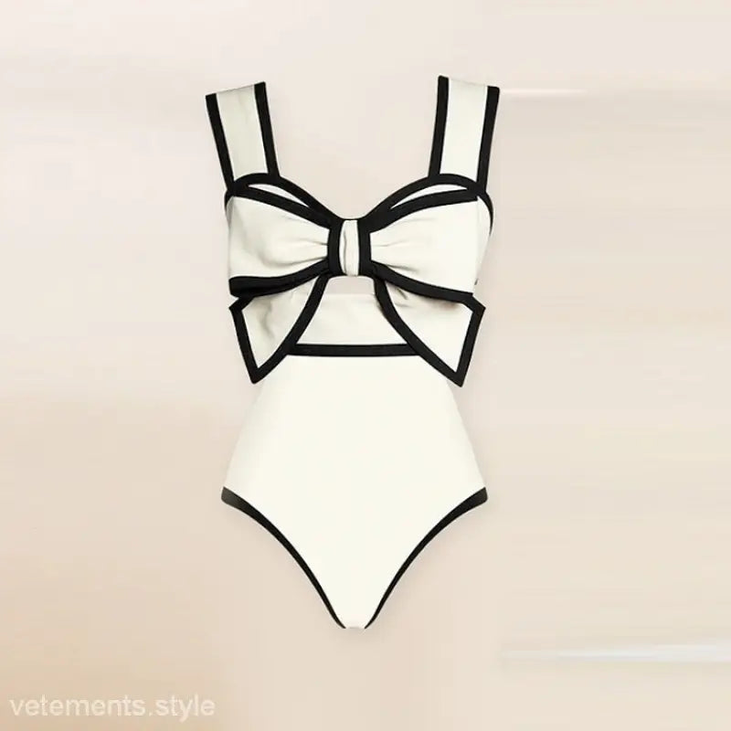 White swimsuit with black trim and bow detail in a chiffon beach skirt set