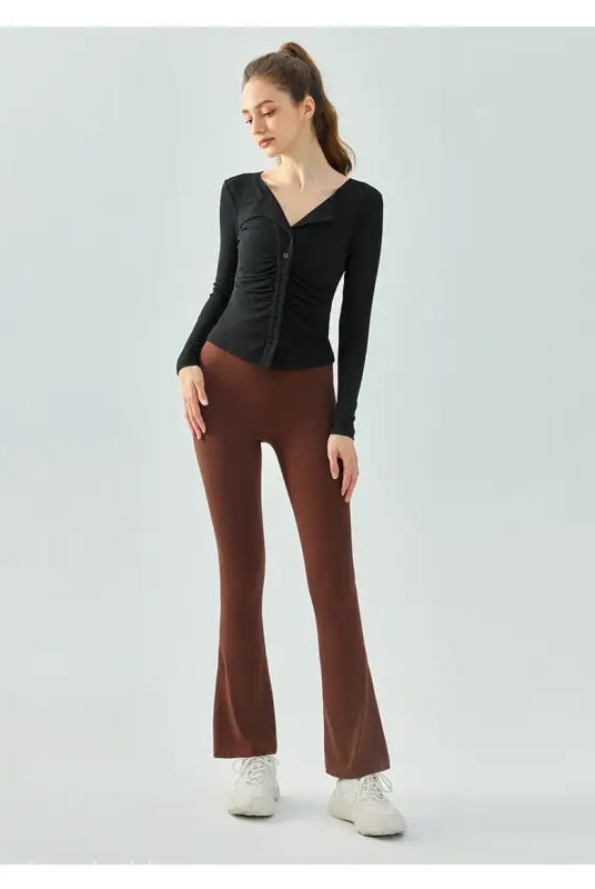 Woman in black top and brown pants modeling Wild Rose Yoga Tee in Milk Tea White