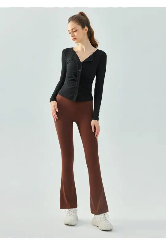 Woman in black top and brown pants modeling Wild Rose Yoga Tee in Milk Tea White