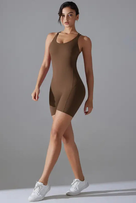 Brown form-fitting bodysuit worn by a woman with white sneakers.