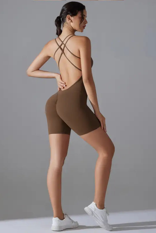 Brown form-fitting bodysuit with crisscross back straps and shorts-length legs.