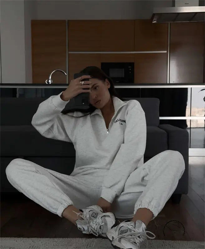Woman in white tracksuit with autumn winter fleece lined half zipper top