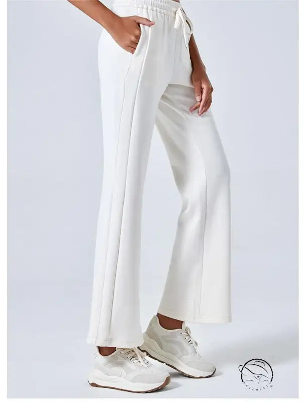 White wide-leg air layer yoga pants with cream sneakers