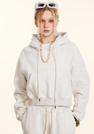 White cropped hoodie with drawstrings and gold chain necklace for stylish winter fashion