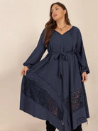 Woman in winter cozy dress with V-neck, waist tie, and lace skirt paneling