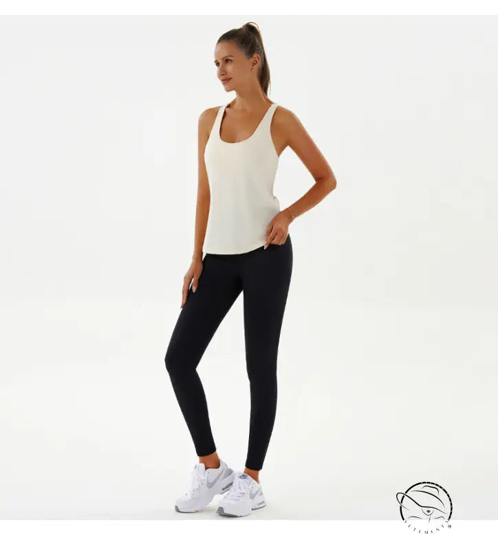 Woman in cream tank top and black leggings, yoga breathable fashion