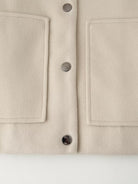 Cream-colored minimalist single breasted Langry fashion jacket coat with pocket details