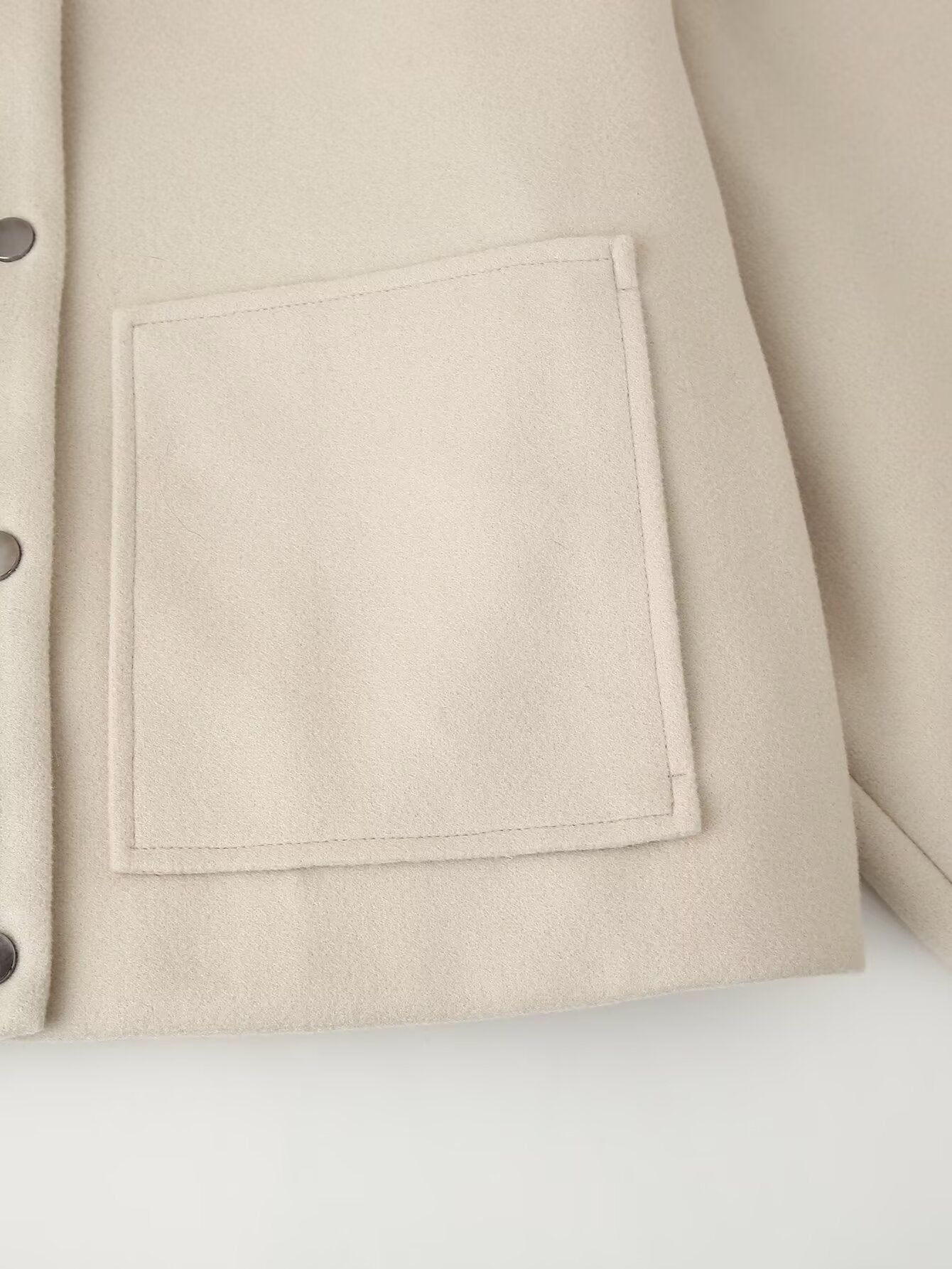 Cream-colored pocket detail with perforated buttons on Langry single breasted jacket